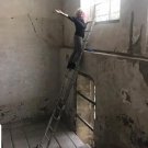 Pamela on a ladder inspecting the panels and how they were installed 280 years ago.